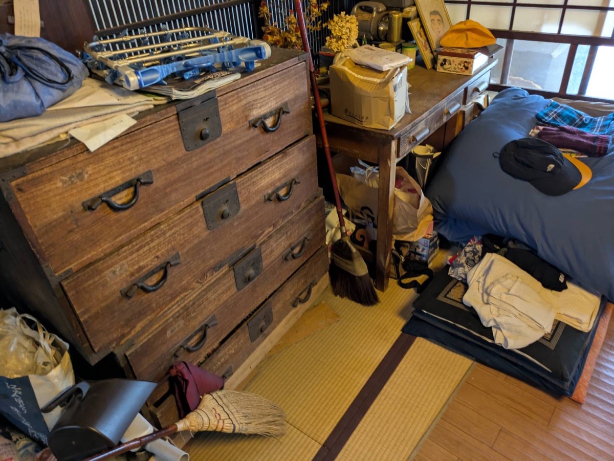 箪笥と寝具、生活用品が残る作業前の室内