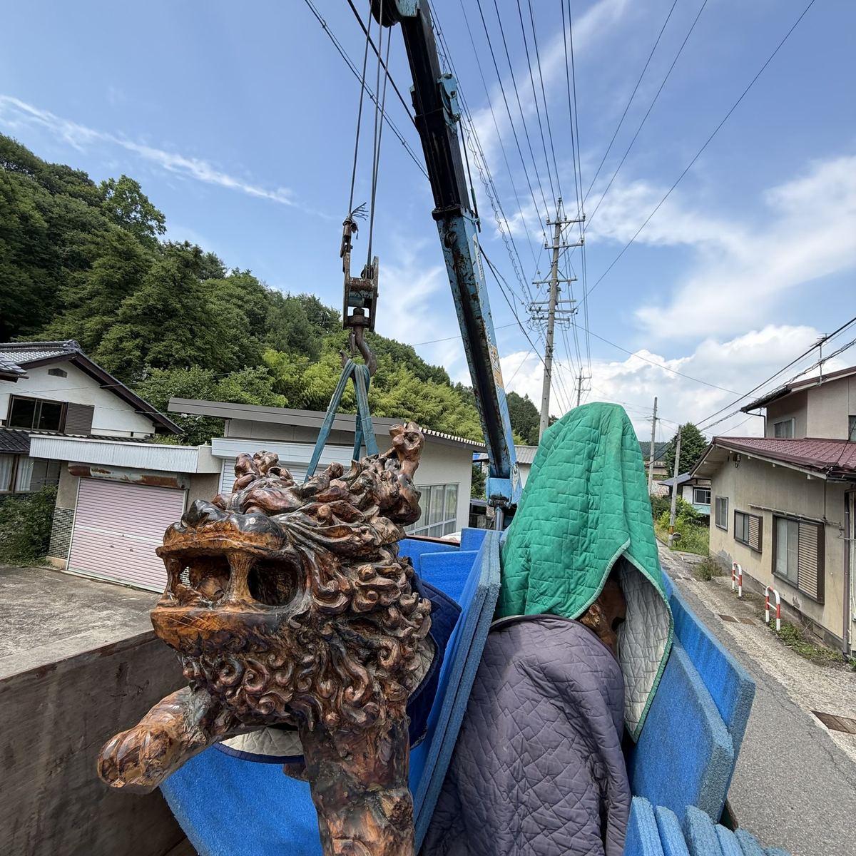 長野県の出張買取で大型の龍の木彫をクレーン搬出する様子